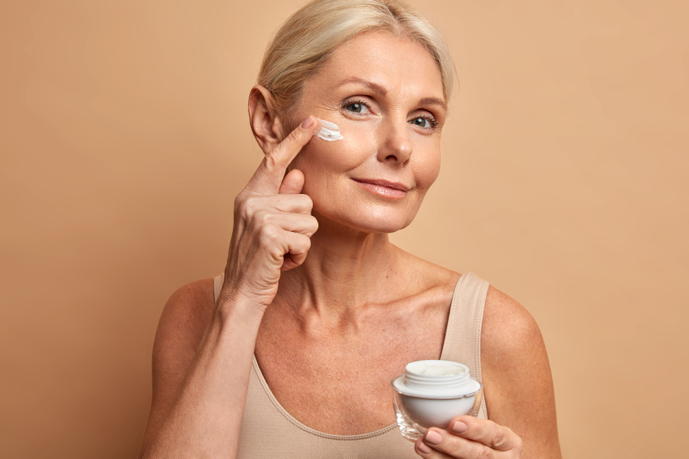 mature woman putting face cream on